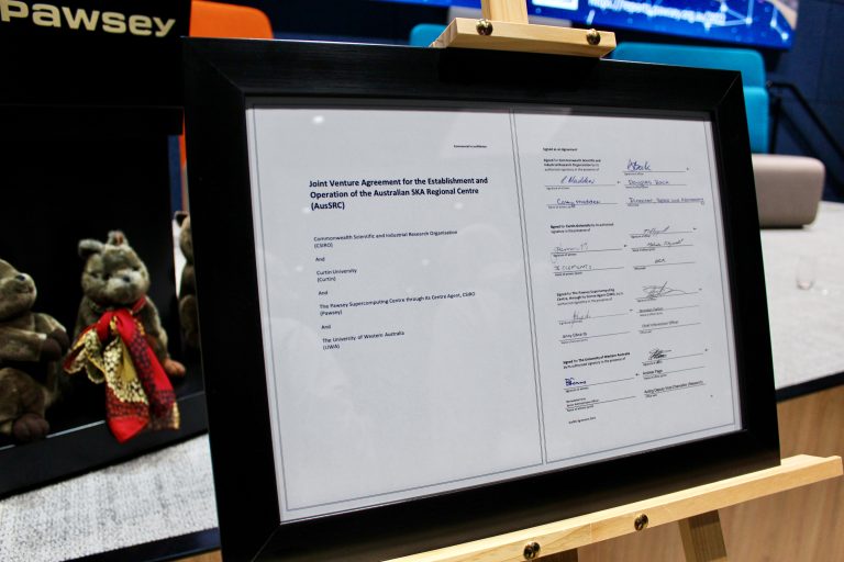 A framed document, showing the signed AusSRC partnership agreement.