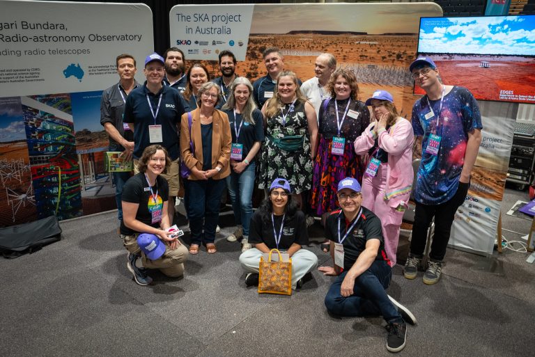 a group of people standing together at the combined AusSRC and SKAO stall at Astrofest 2023